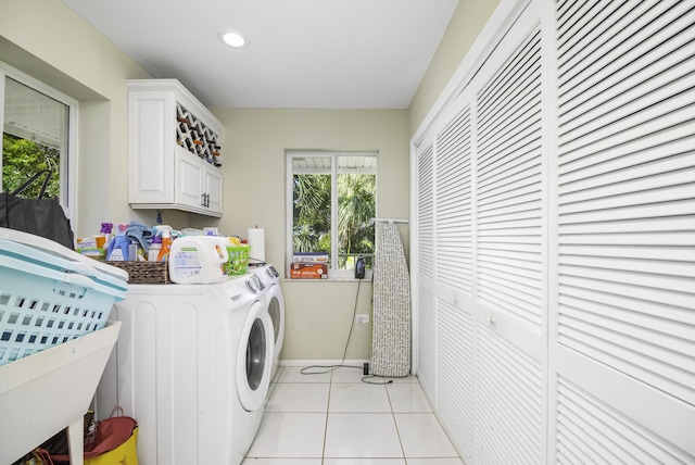 laundry area with cabinets, light tile patterned floors, and independent washer and dryer