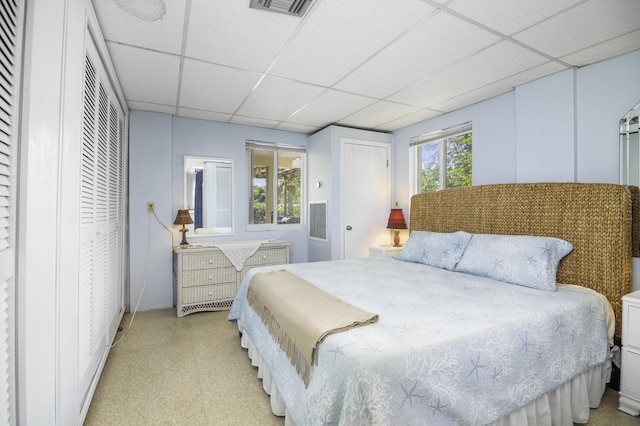 bedroom with a paneled ceiling and multiple windows