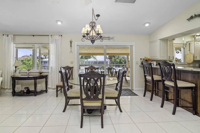 dining area featuring plenty of natural light, vaulted ceiling, and light tile patterned floors