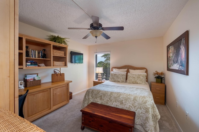 carpeted bedroom featuring ceiling fan and a textured ceiling