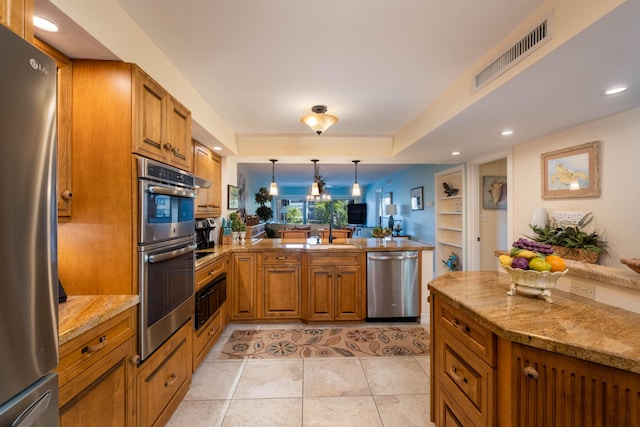 kitchen featuring light tile patterned floors, appliances with stainless steel finishes, light stone counters, decorative light fixtures, and kitchen peninsula