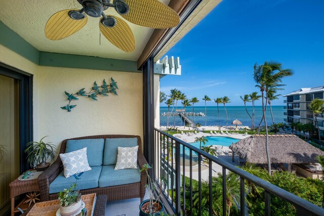 balcony featuring a water view and ceiling fan