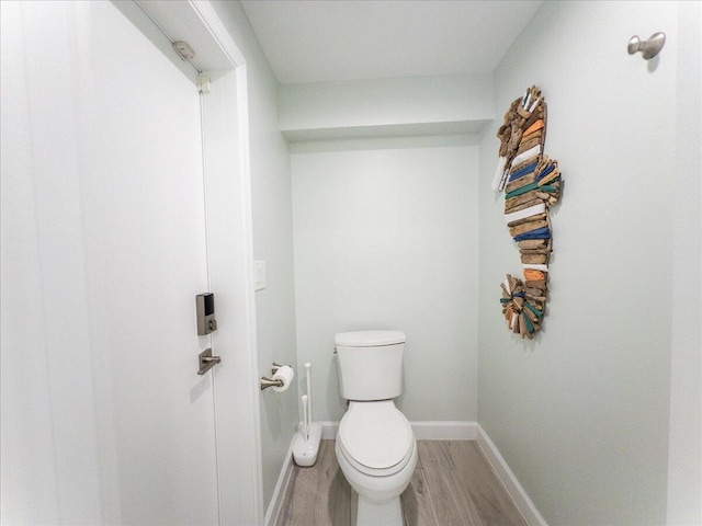 bathroom with hardwood / wood-style flooring and toilet