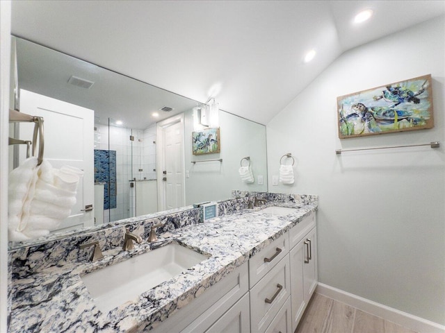 bathroom with vanity, an enclosed shower, vaulted ceiling, and wood-type flooring