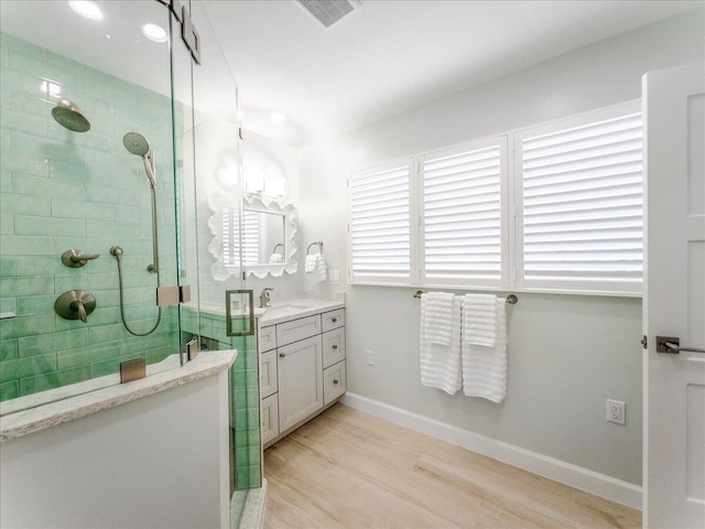 bathroom with vanity, hardwood / wood-style flooring, and a shower with shower door