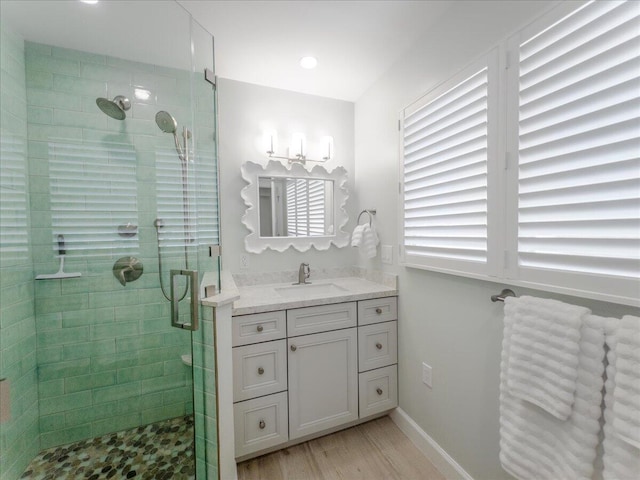 bathroom with hardwood / wood-style flooring, vanity, and a shower with door