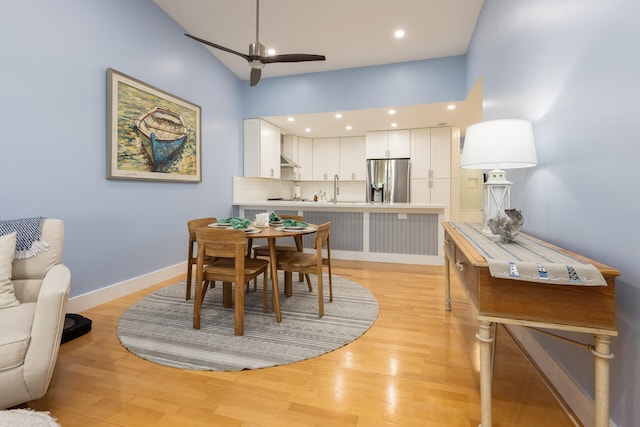 dining space with light hardwood / wood-style floors, ceiling fan, and sink