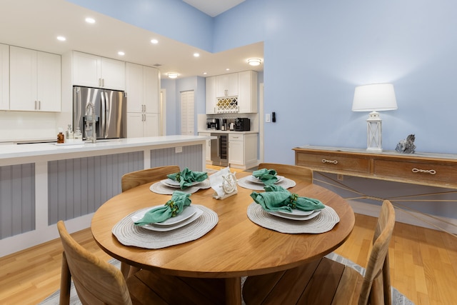 dining space featuring light hardwood / wood-style floors and beverage cooler