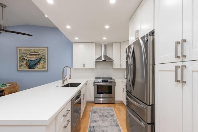 kitchen with white cabinetry, appliances with stainless steel finishes, sink, and wall chimney exhaust hood