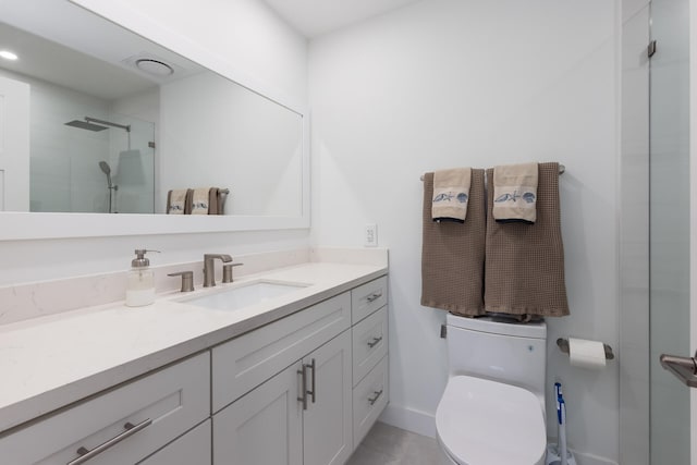 bathroom featuring toilet, vanity, and walk in shower