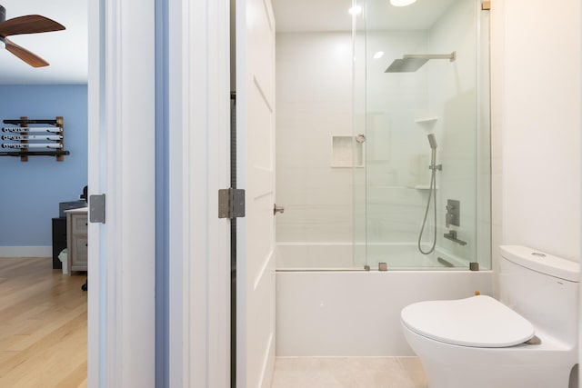 bathroom with ceiling fan, toilet, shower / bath combination with glass door, and hardwood / wood-style floors