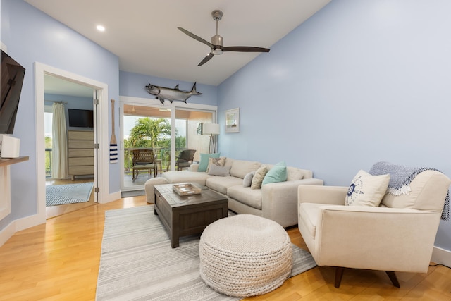 living room featuring vaulted ceiling, ceiling fan, and light hardwood / wood-style flooring