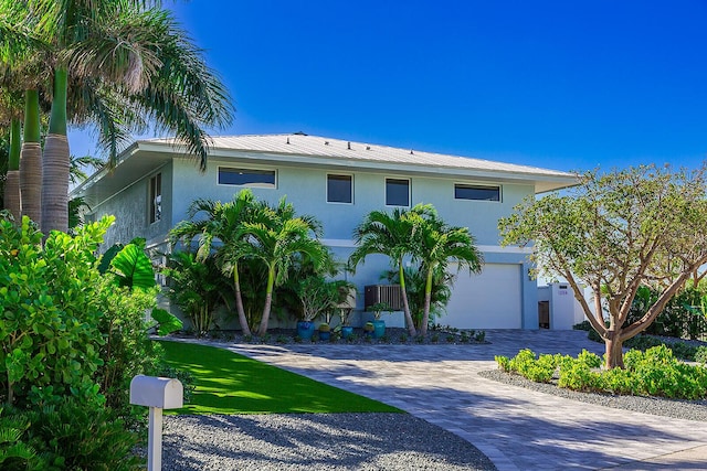 view of front of property featuring a garage and central air condition unit