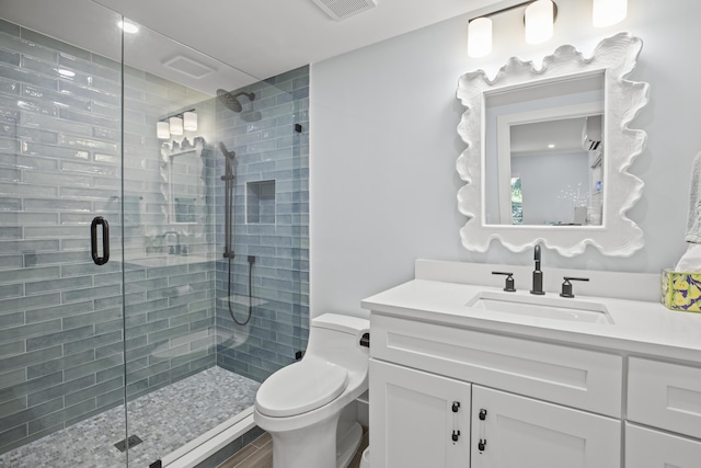 bathroom featuring vanity, toilet, and an enclosed shower