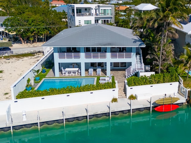 back of house with a patio and a water view