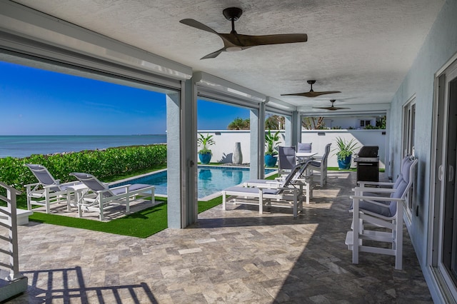 view of patio with a fenced in pool, grilling area, a water view, and ceiling fan