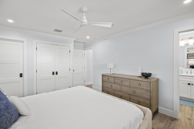 bedroom with connected bathroom, crown molding, light hardwood / wood-style flooring, a closet, and ceiling fan