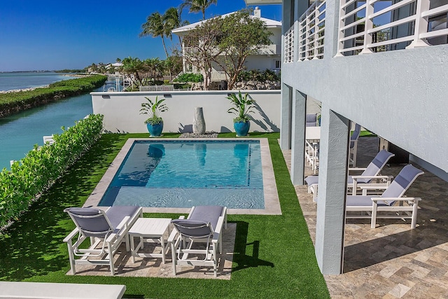 view of pool featuring a patio and a water view