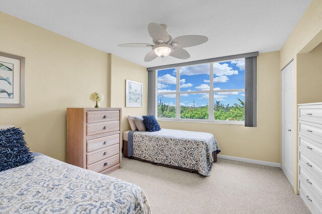 bedroom featuring baseboards, ceiling fan, and light colored carpet