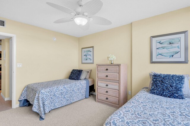 bedroom featuring light carpet, baseboards, visible vents, and a ceiling fan