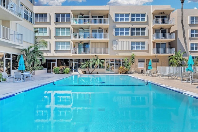 community pool with a patio area and a ceiling fan