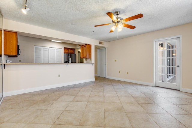 3930 S Roosevelt Blvd Unit N302, Key West, FL 33040 - unfurnished living room with a ceiling fan, a textured ceiling, baseboards, and light tile patterned floors