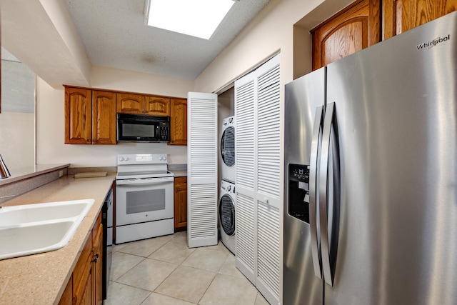 3930 S Roosevelt Blvd Unit N302, Key West, FL 33040 - kitchen featuring stainless steel refrigerator with ice dispenser, white electric range, black microwave, stacked washer and clothes dryer, and brown cabinets