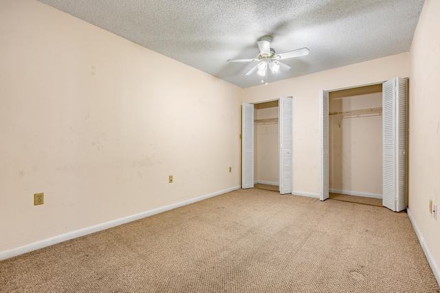 3930 S Roosevelt Blvd Unit N302, Key West, FL 33040 - unfurnished bedroom featuring multiple closets, carpet floors, a textured ceiling, baseboards, and ceiling fan