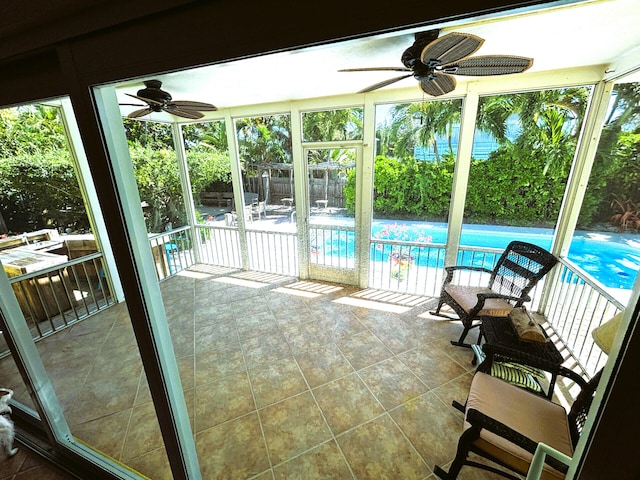 unfurnished sunroom with a ceiling fan