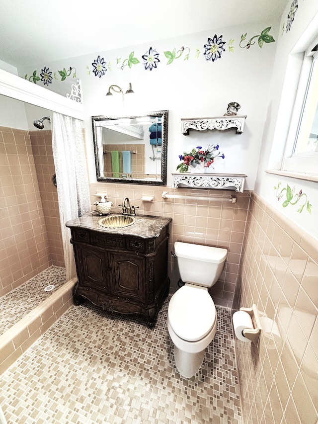 full bath with tile walls, toilet, a shower stall, vanity, and a wainscoted wall