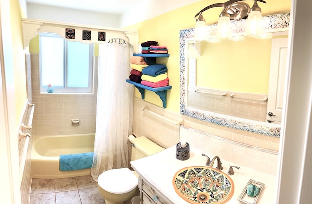 bathroom featuring vanity, toilet, wainscoting, shower / tub combo with curtain, and tile walls