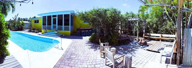 view of swimming pool with a sunroom, a patio, and a fenced in pool