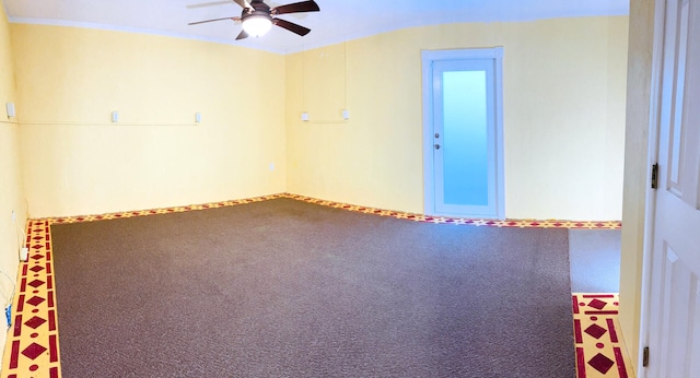 carpeted spare room with a ceiling fan