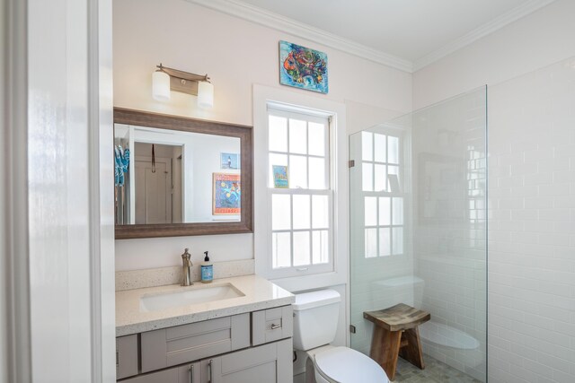 bathroom with tiled shower, ornamental molding, toilet, and vanity