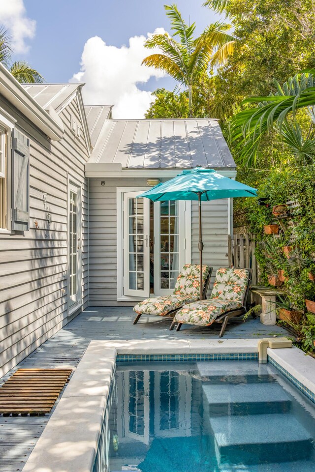 view of pool featuring french doors and a deck