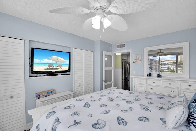 bedroom featuring black fridge, ceiling fan, and a textured ceiling