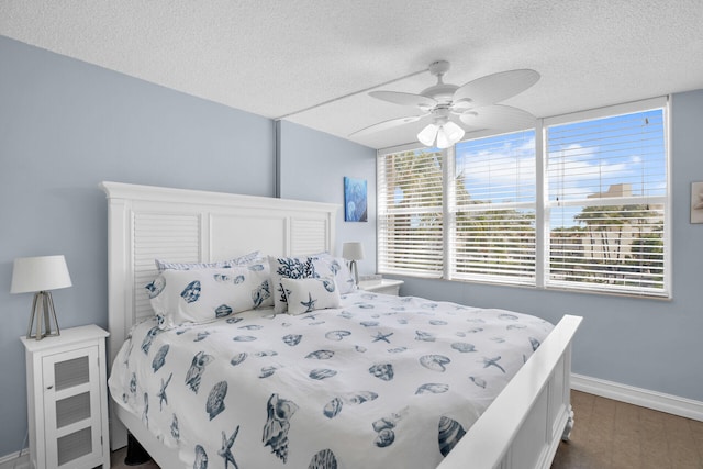 bedroom with ceiling fan, dark hardwood / wood-style floors, and a textured ceiling