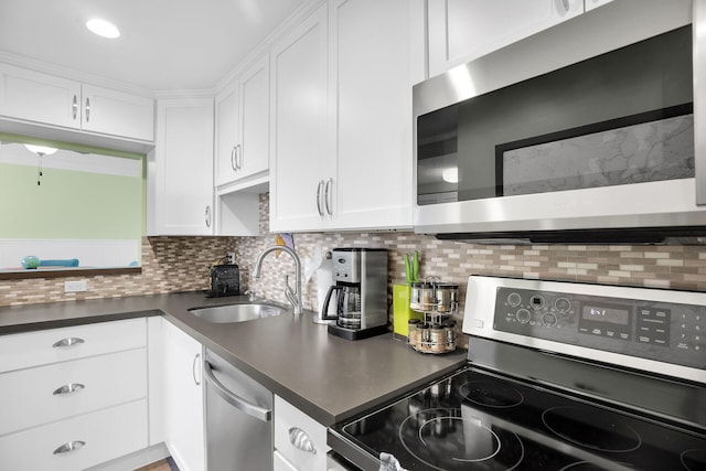 kitchen with stainless steel appliances, sink, decorative backsplash, and white cabinets