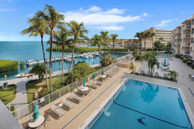 view of swimming pool with a patio and a water view