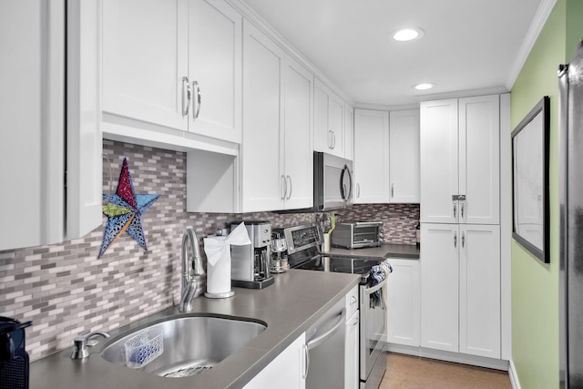 kitchen featuring sink, white cabinetry, stainless steel appliances, ornamental molding, and decorative backsplash