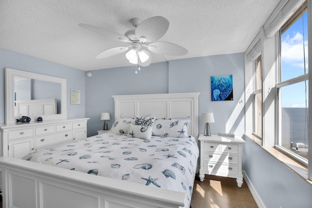 bedroom featuring ceiling fan and a textured ceiling