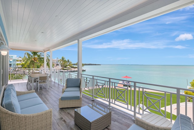 deck with an outdoor living space and a water view