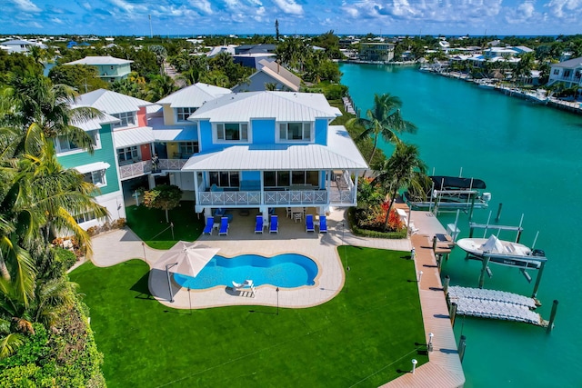 view of swimming pool with a water view, a yard, and a patio area