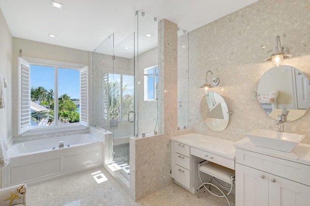 bathroom featuring vanity and independent shower and bath