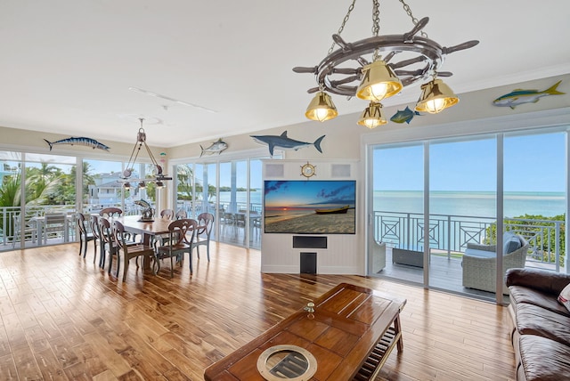 dining room with ornamental molding and light hardwood / wood-style flooring