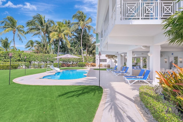 view of swimming pool with a patio area, a lawn, and a water slide