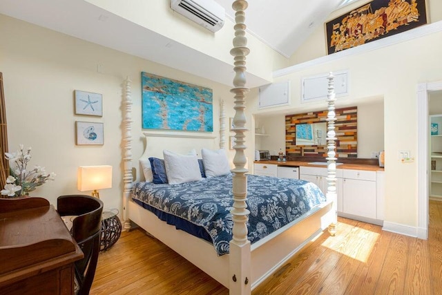 bedroom featuring an AC wall unit, light wood-type flooring, and lofted ceiling