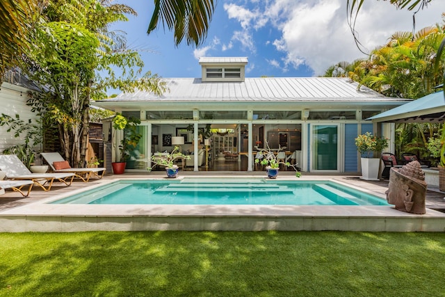 back of property with a gazebo, metal roof, and an outdoor pool