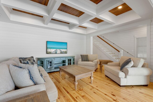 living area with stairway, light wood-type flooring, beam ceiling, coffered ceiling, and wooden walls