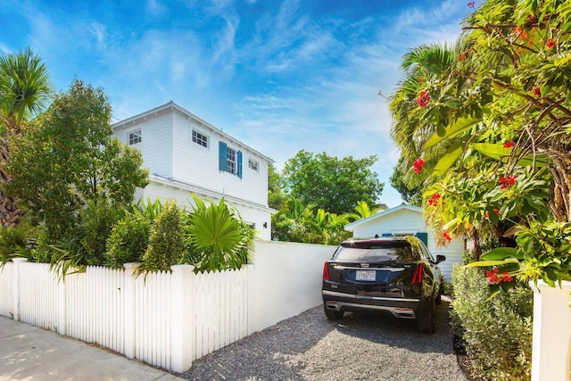view of side of home with fence and a garage